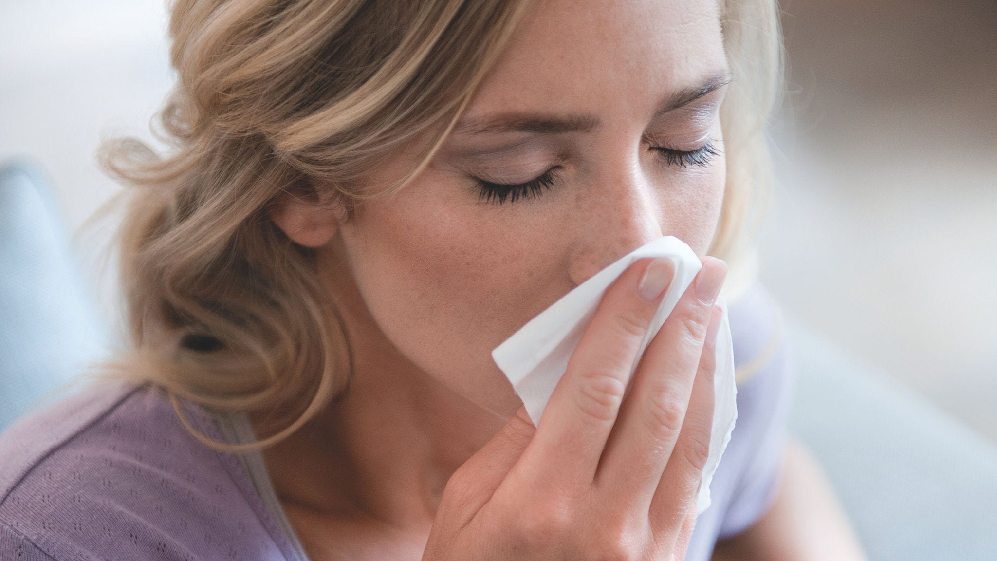 Жена издухва носа си поради поленова алергия