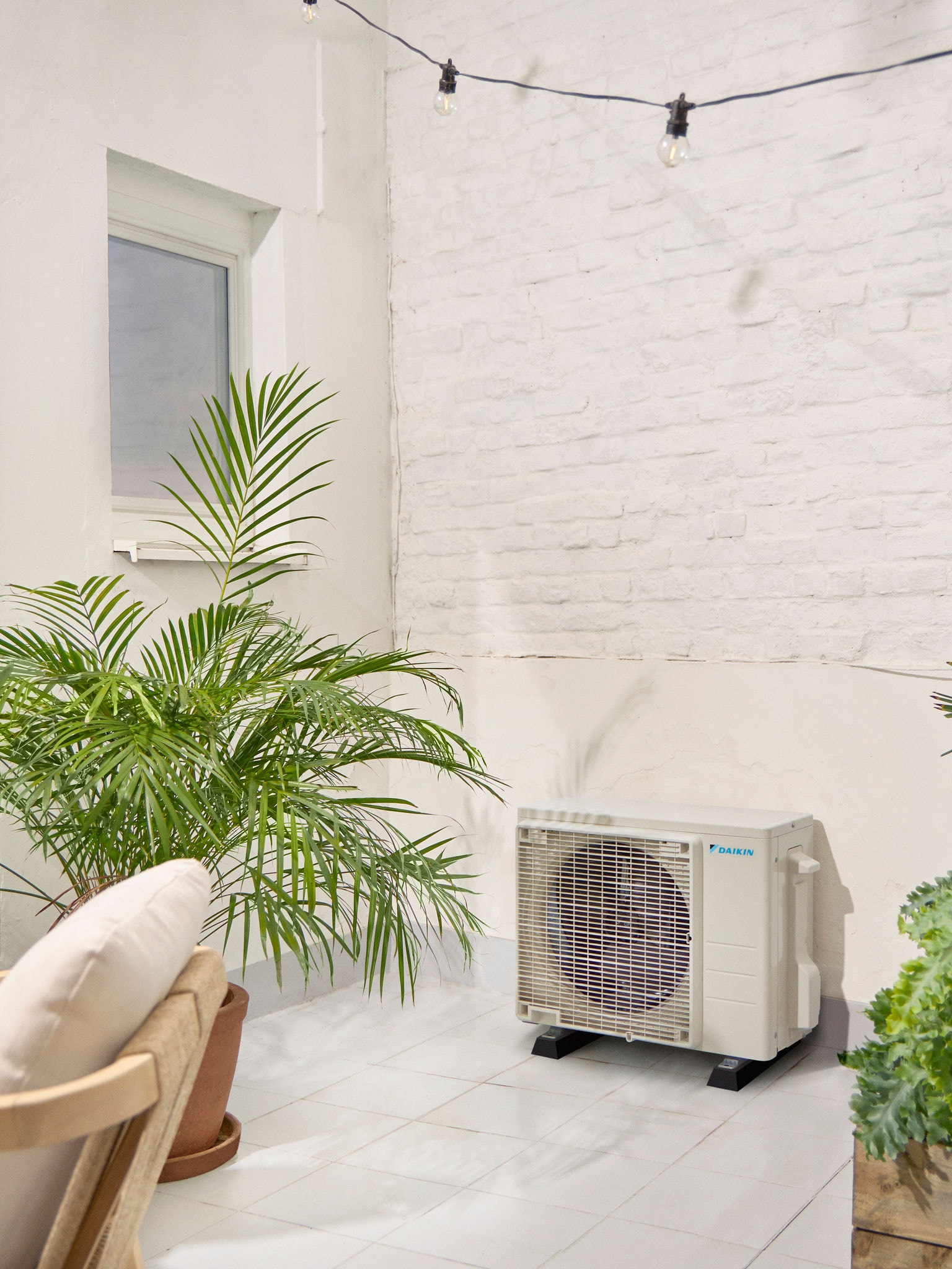 Външно тяло Daikin на бяла тераса с растение