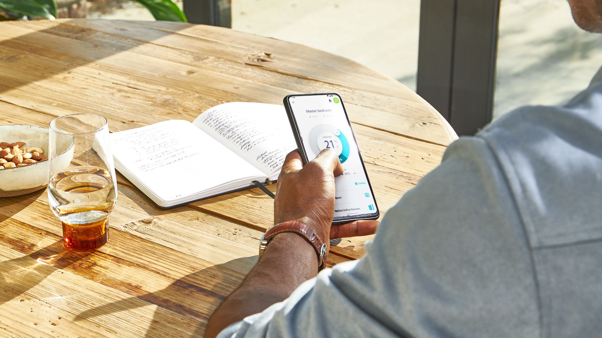 Човек управлява в дома си отвсякъде с помощта на приложението Daikin Onecta на смартфон