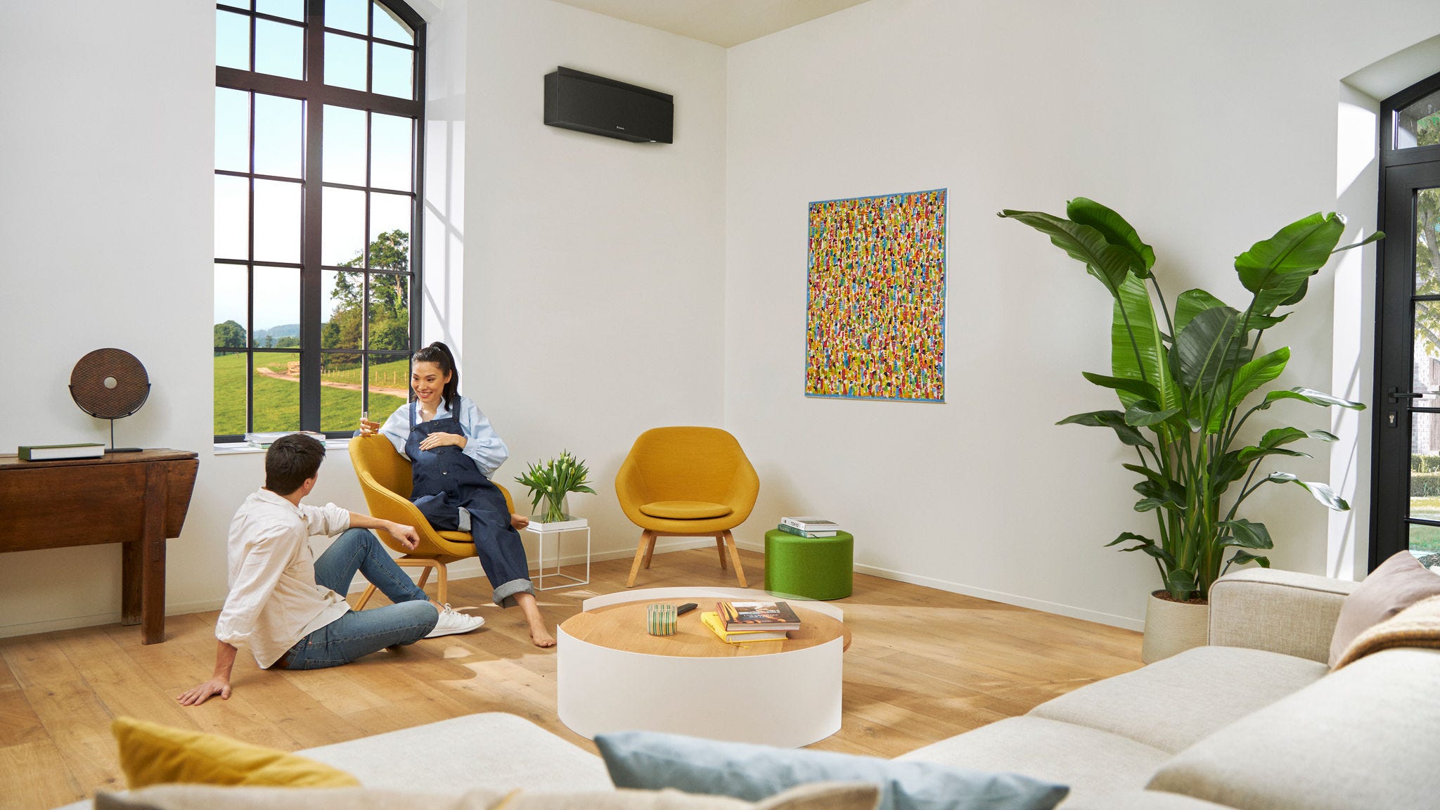 Двойка с бременна жена говори спокойно, докато жената седи на стол