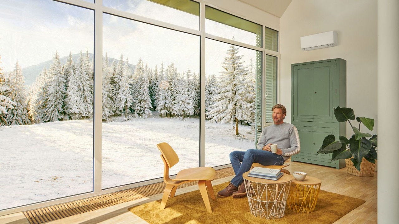 Мъж седи на дивана и се наслаждава на отопление с климатик