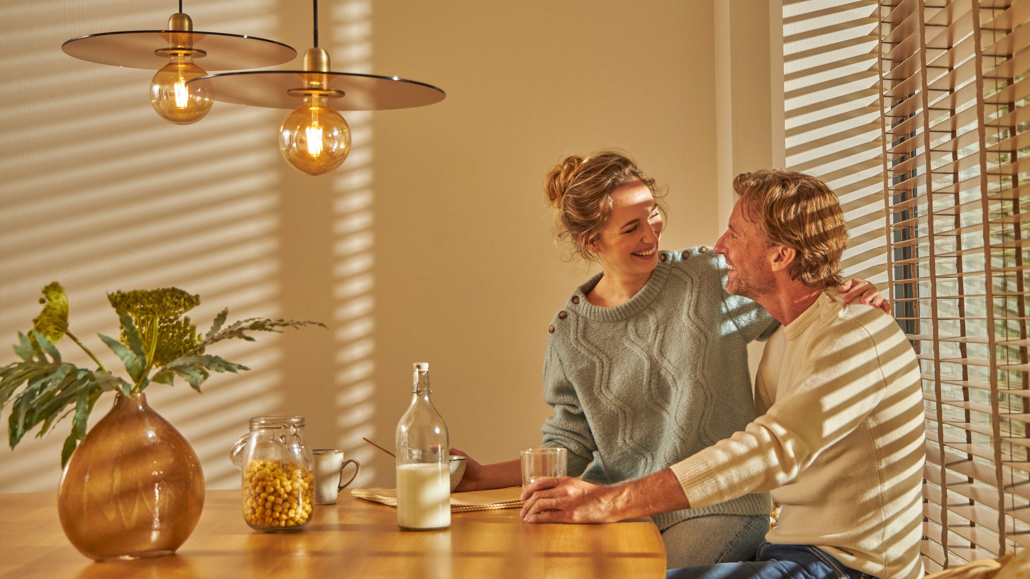 Двойка се наслаждава на уютна закуска заедно в своята комфортно топла кухня благодарение на тази интуитивна технология за отопление