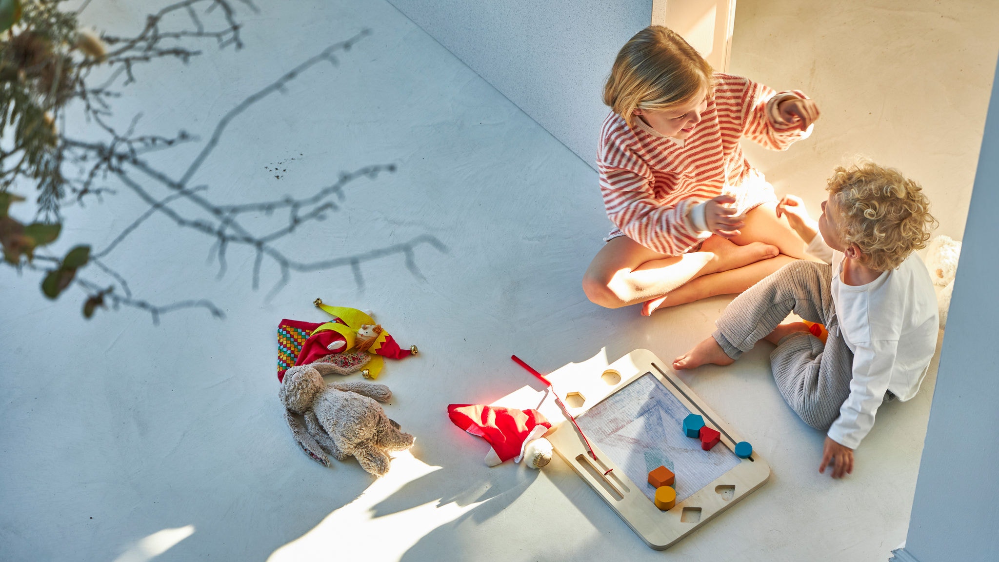 Брат и сестра си играят на земята, наслаждавайки се на комфортната температура, осигурена от геотермалната термопомпа Daikin