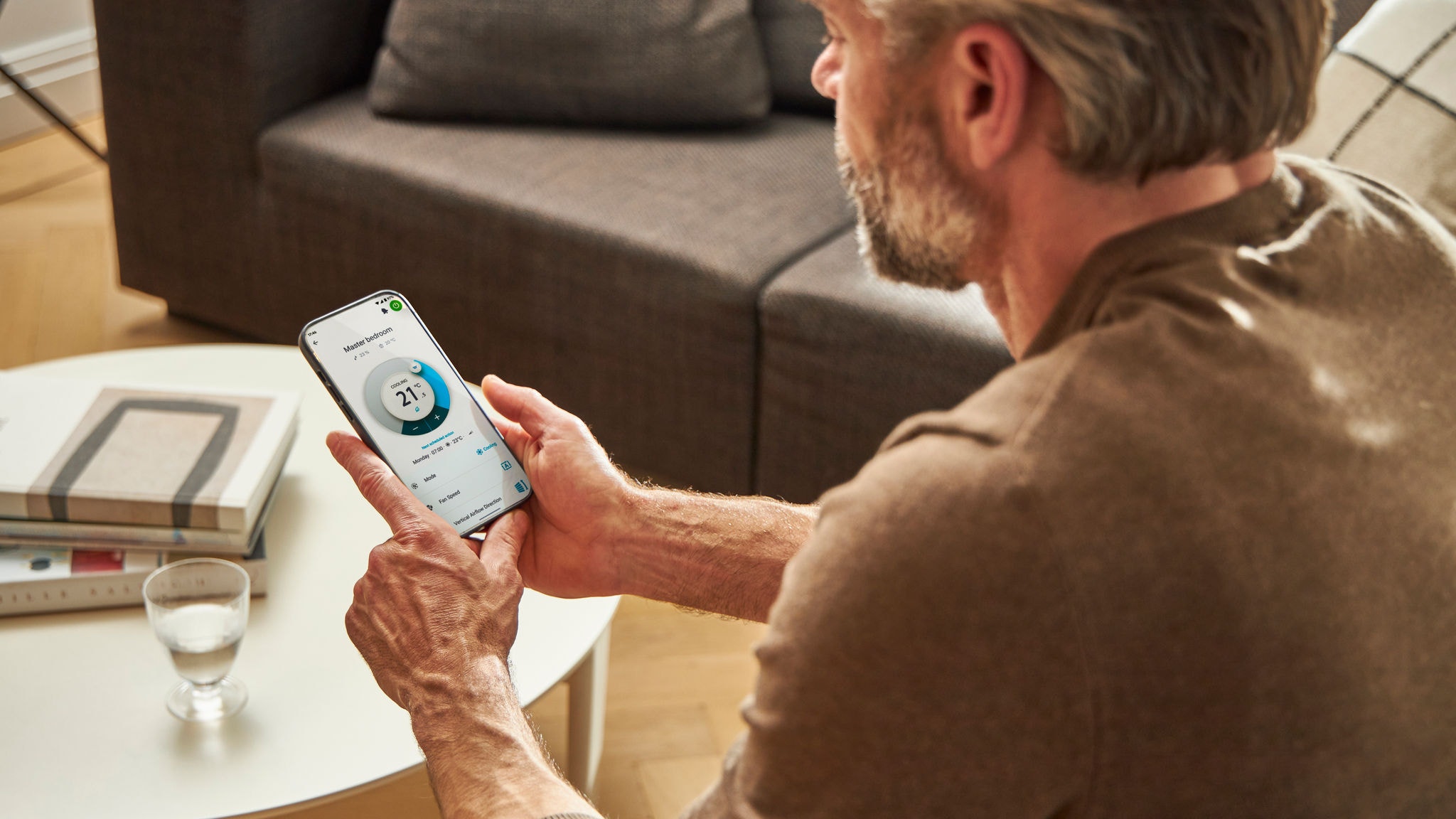 Човек, използващ приложение, за да управлява своето решение за отопление