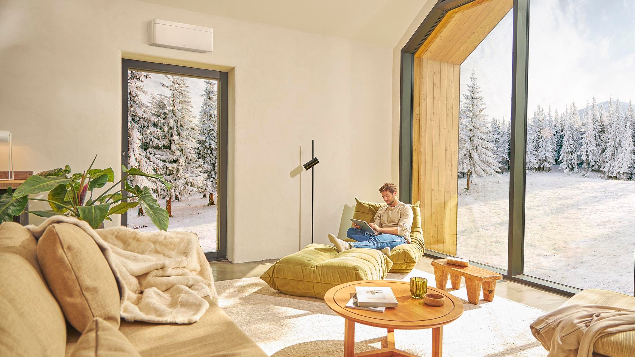 Мъж седи на дивана и се наслаждава на отопление с климатик