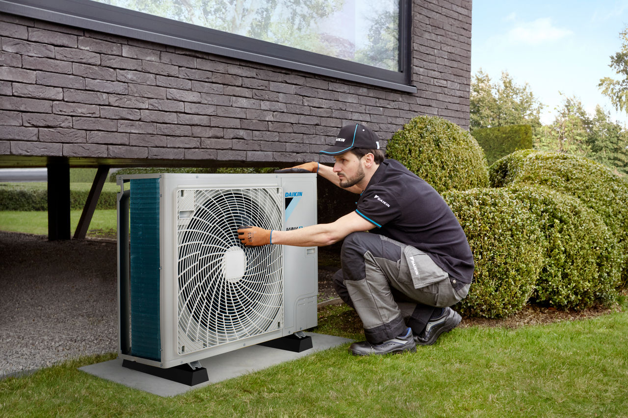 Инженер, обслужващ термопомпа на Daikin